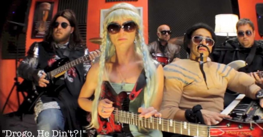 A woman with long blonde hair is with band with guitar in her lap