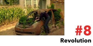 A woman tends a garden grown out of an old rusty car.