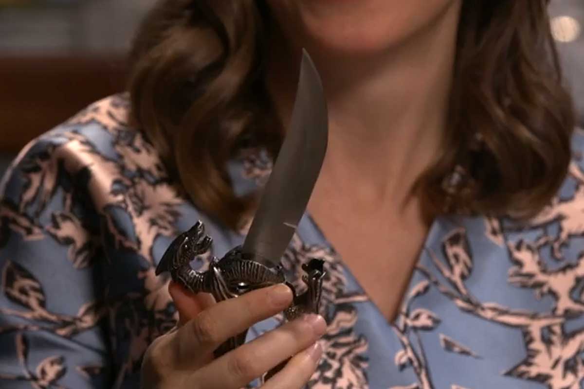 A woman is puzzled as she examines the dagger rattle for her baby