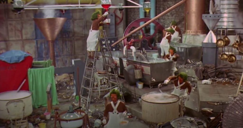 a group of oompa loompas work in willy wonkas factory