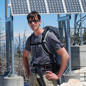 a man stands in front of solar panels